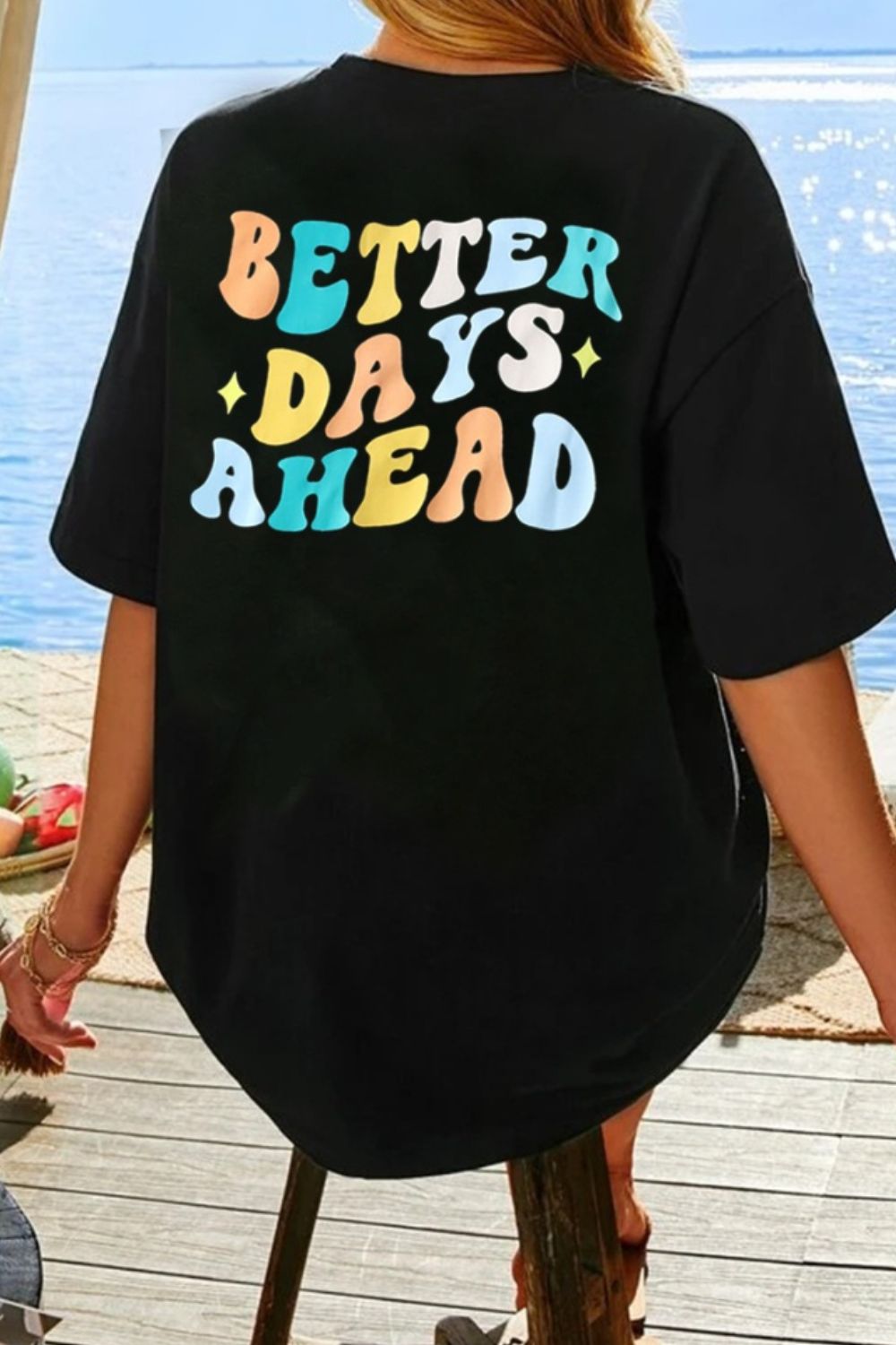 Black oversized graphic tee with retro "BETTER DAYS AHEAD" text in colorful wavy font.