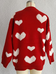 Red knit sweater with textured white heart appliqués, long sleeves, and crew neck.