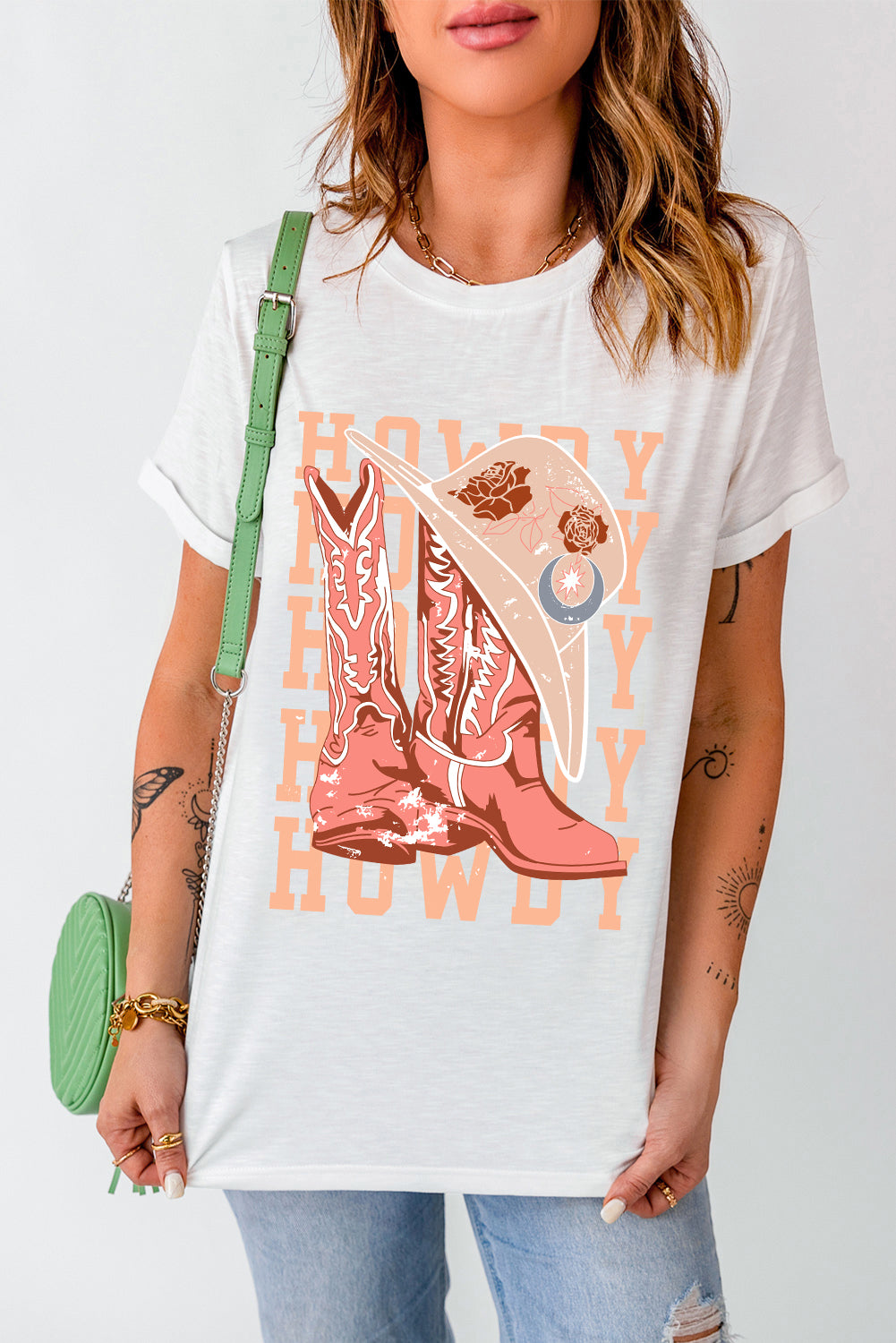 White cotton blend graphic tee with cowboy boots and hat print and "Howdy" text.