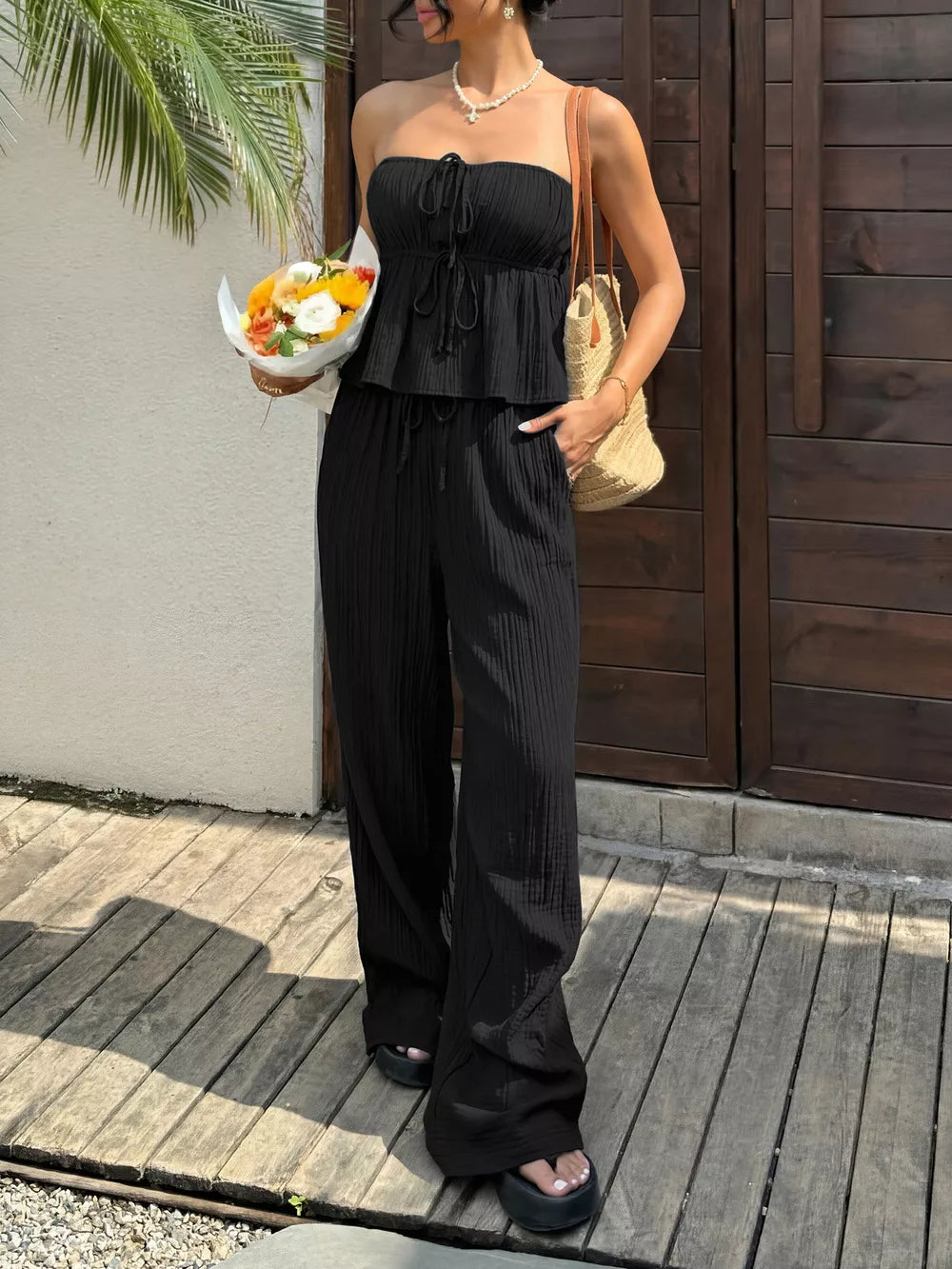 Black tube top and wide-leg pants set with drawstring details and pockets.