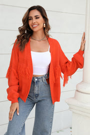 Orange acrylic cardigan with fringe detail on sleeves and hem.