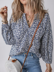 Blouse with navy floral print, V-neck, and long sleeves.
