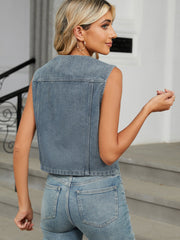 Cropped denim utility vest in medium wash, button-front style.