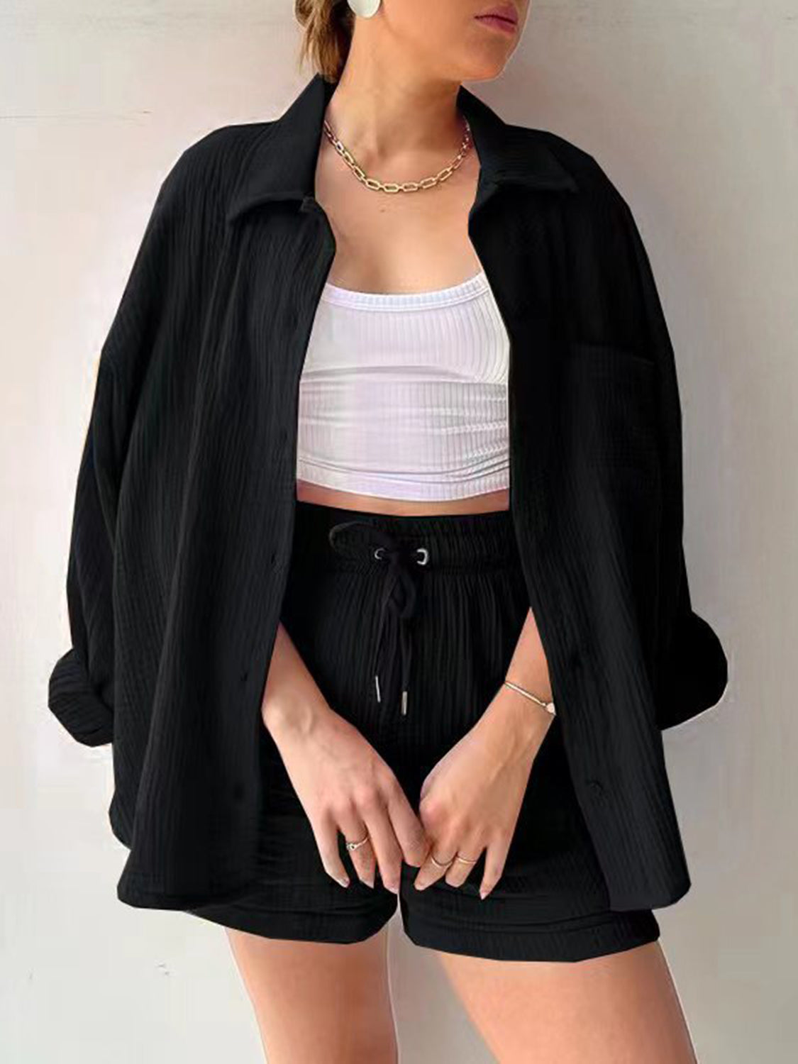 Black textured gauze button-up shirt and drawstring shorts set styled with a white crop top.