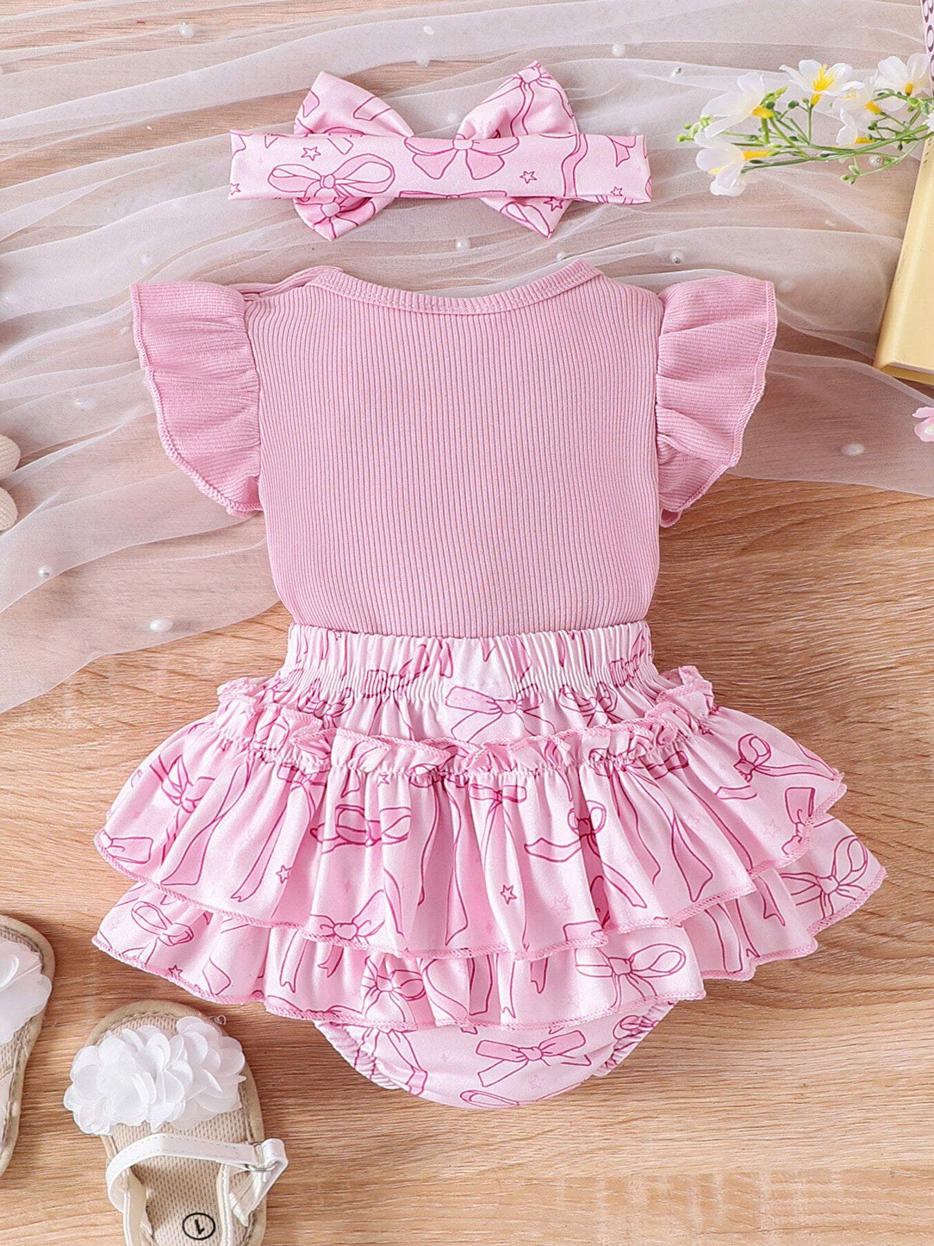 Pink baby bodysuit with ruffled sleeves and bowknot print skort, includes matching headband.