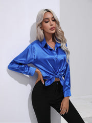 Royal blue satin tie-front blouse with buttoned front and collared neckline.
