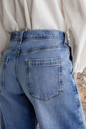 Light wash denim jeans with subtle stitch detail on back pockets.