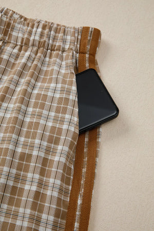 Plaid casual pants with drawstring waist and side pocket holding a phone.