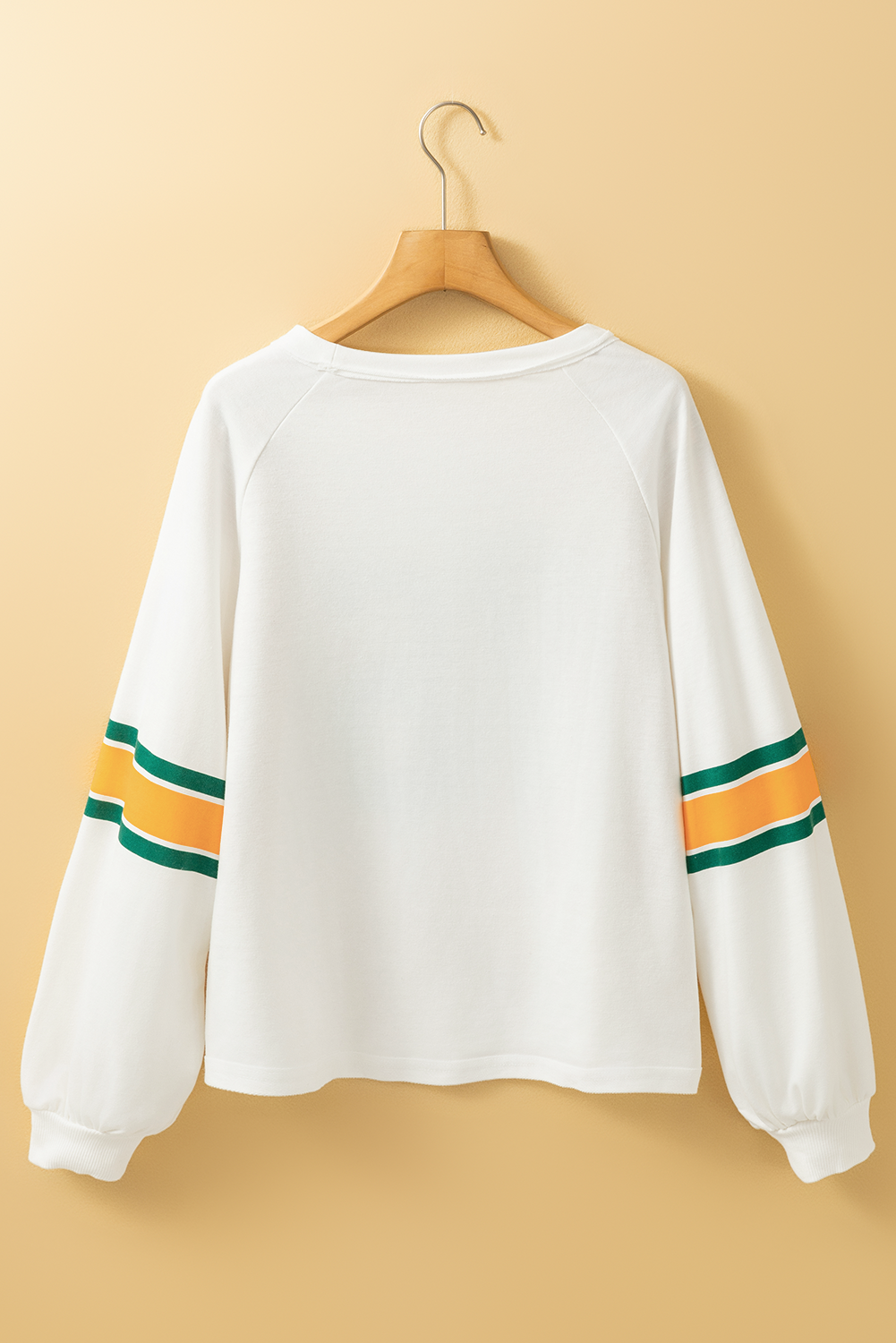 White raglan sleeve sweatshirt with green and orange stripes on sleeves.