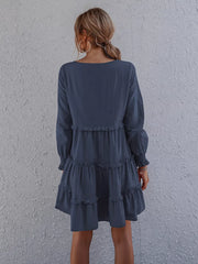 Navy blue ruffled mini dress with long sleeves and tiered skirt.