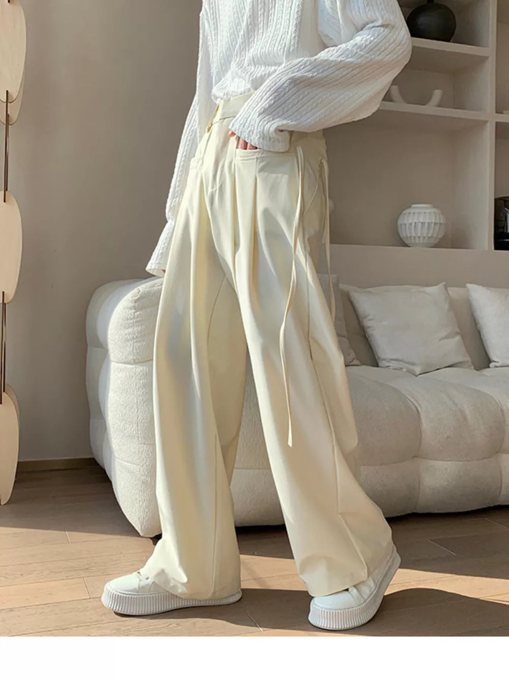 Men's wide-leg casual trousers in off-white with drawstring detail and pockets.