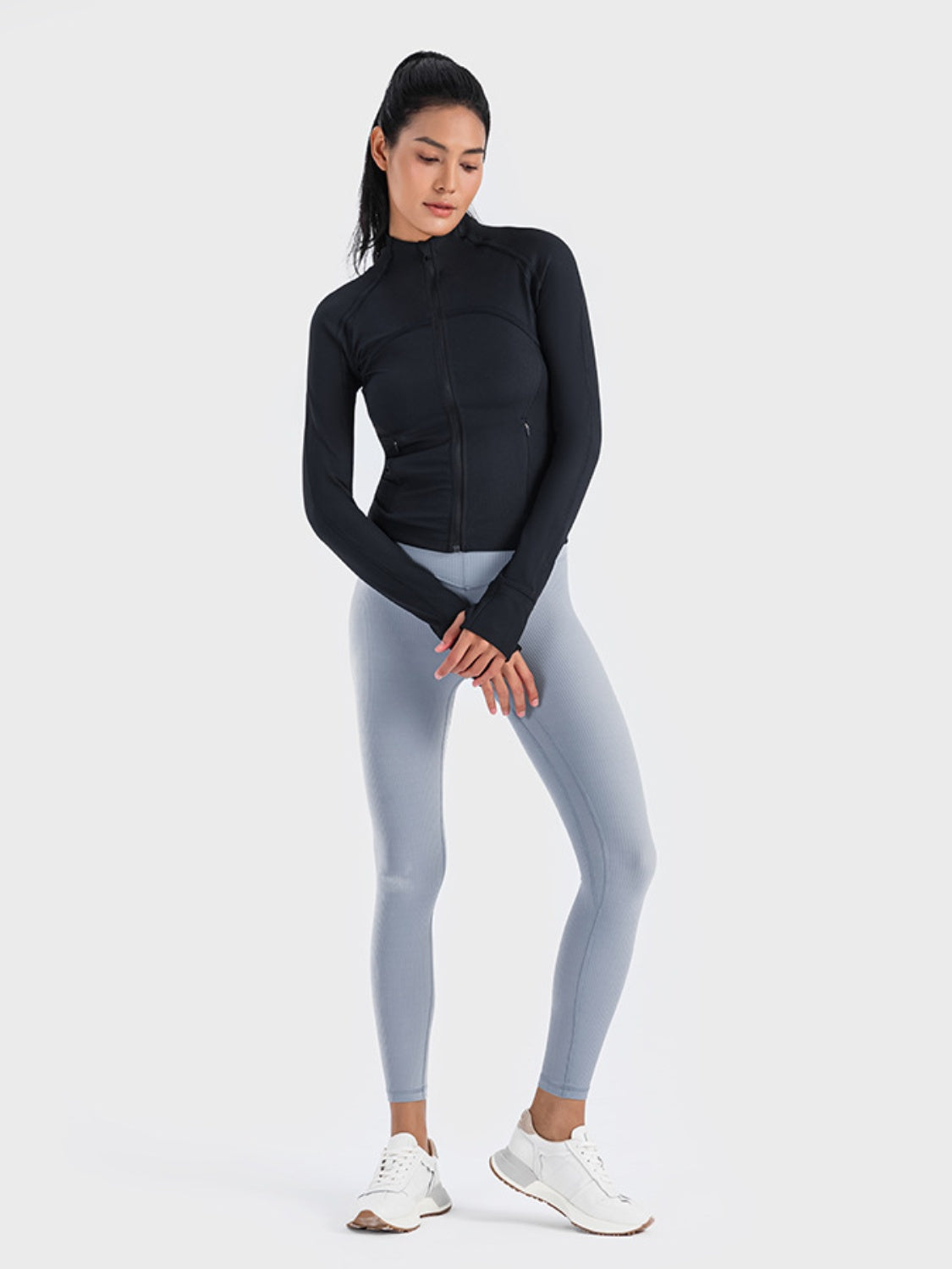 Black ribbed performance zip-up track jacket with thumbholes and zippered pockets.
