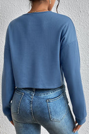 Dusty blue waffle knit henley crop top with long sleeves.