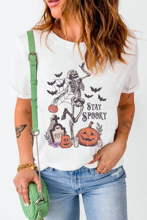 White graphic t-shirt with skeleton, pumpkins, bats, and RIP tombstone.