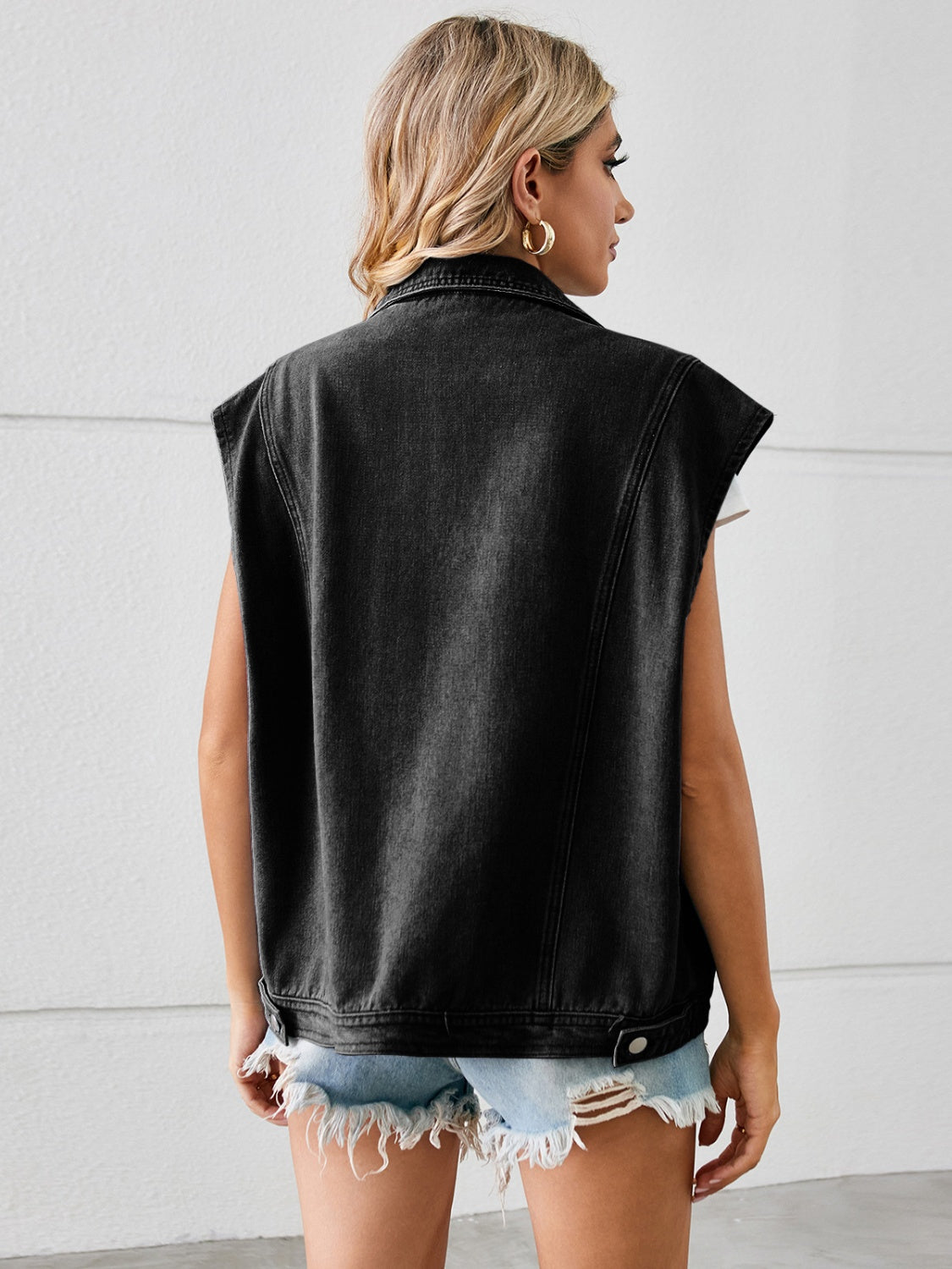 Black denim sleeveless blazer vest with collar and button detail.