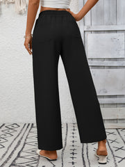 Black drawstring wide-leg pants with back pockets and a relaxed fit.
