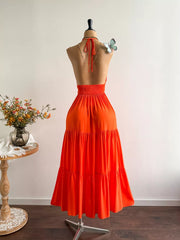 Orange tiered maxi dress with halter neck and cinched waist, backless design