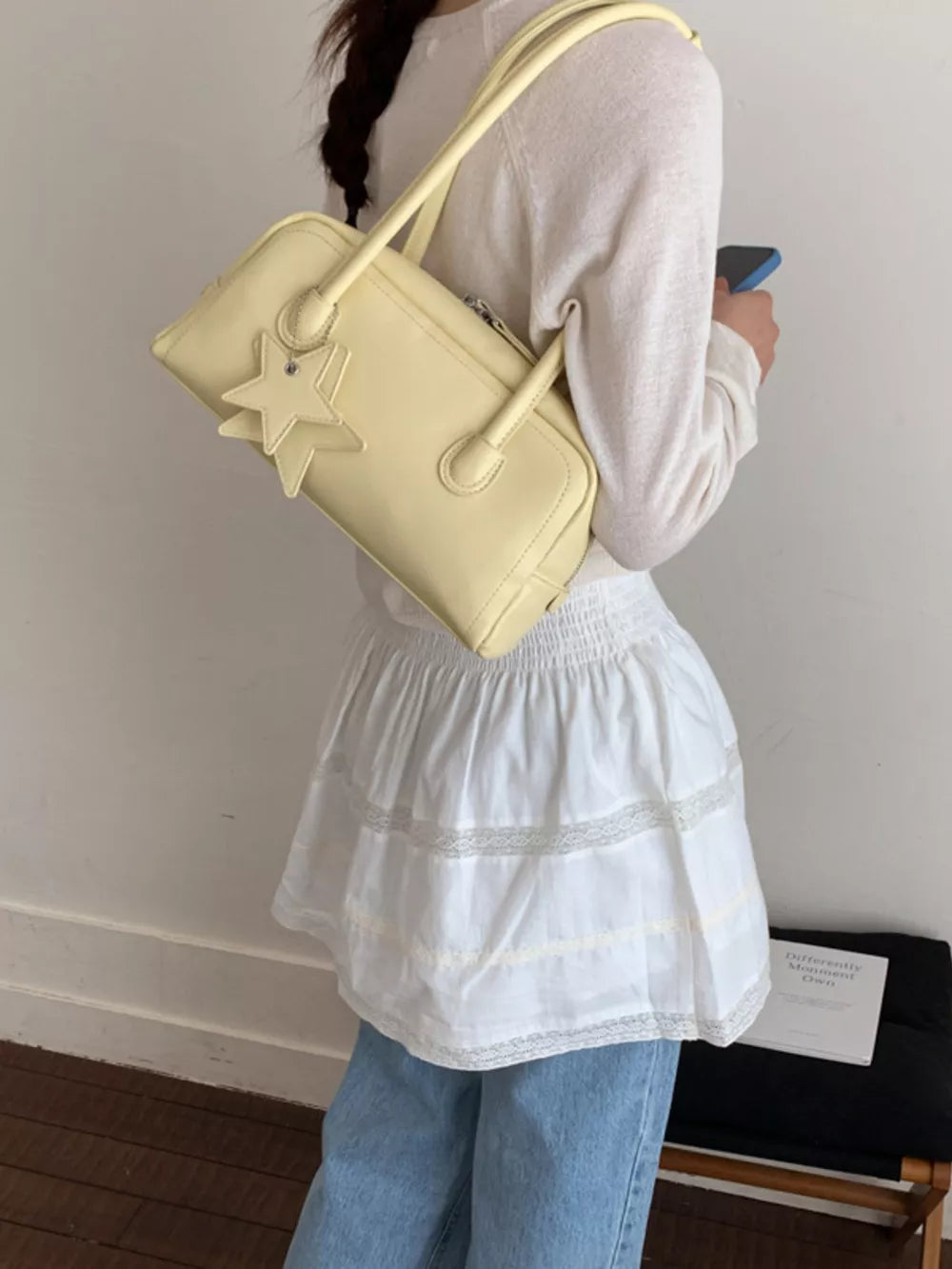 Yellow mini shoulder bag with star charm and double straps.