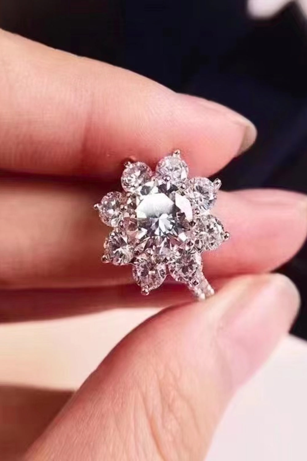 Silver moissanite engagement ring with a flower petal cluster design.