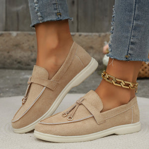 Khaki decorative strap flat slip-ons with tassel detail and contrast piping.
