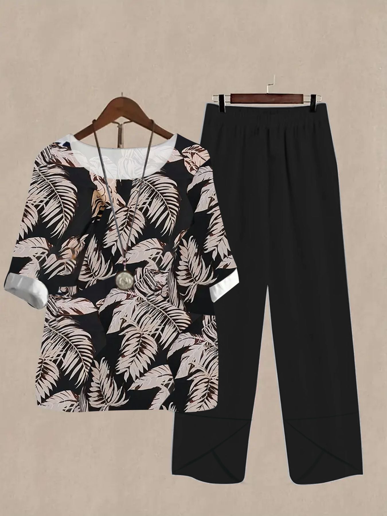 Black floral print half sleeve top and black pants set with white cuffs and neckline detail.