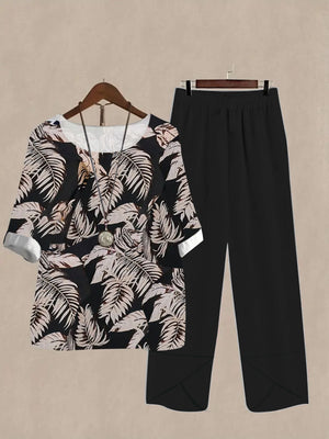 Black floral print half sleeve top and black pants set with white cuffs and neckline detail.