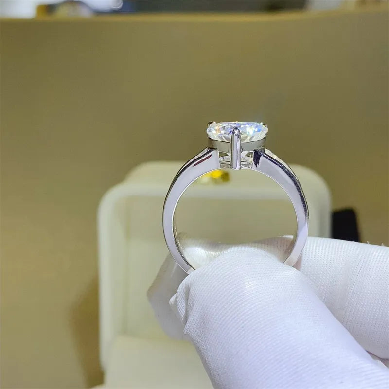 Silver band ring with a heart-cut moissanite and baguette accents.