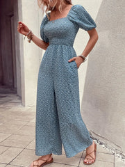 Smocked bodice floral wide-leg jumpsuit in dusty blue with puff sleeves and square neckline.