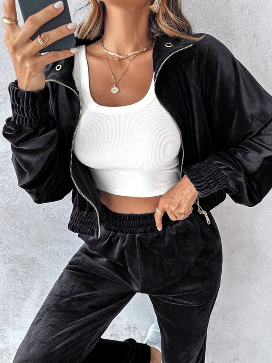 Black velvet crop tracksuit jacket with zipper detail and ruched cuffs.