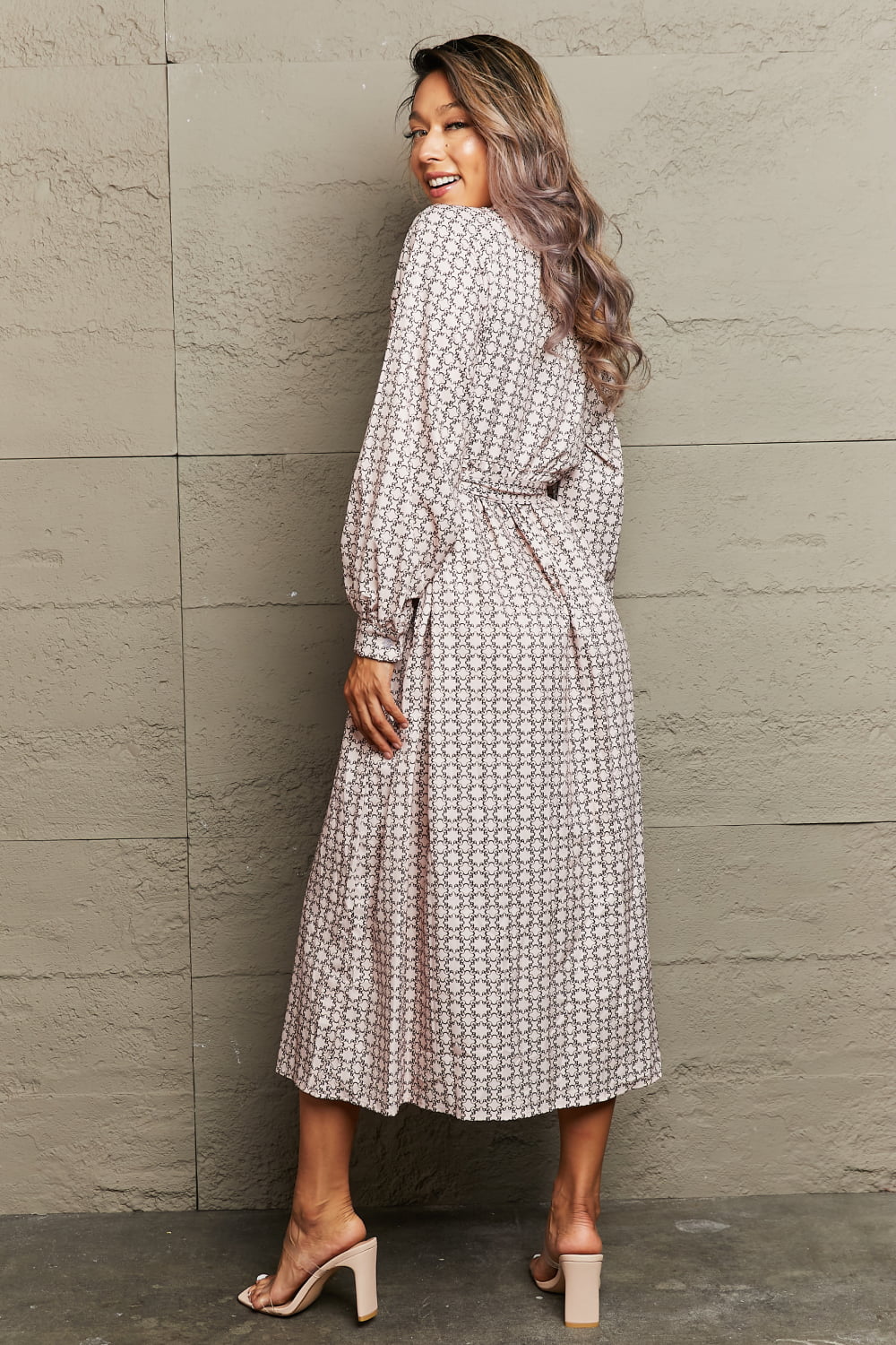 Beige geometric print midi dress with belt and long sleeves.