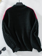 Black cable knit sweater with contrast pink shoulder detail and mock neck.