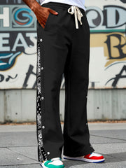 Black sweatpants with side snaps and bandana print stripe detail.