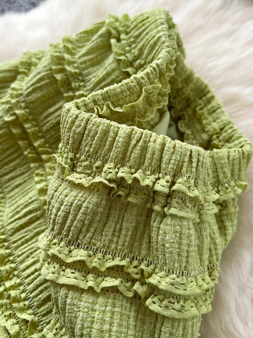 Green ruched polyester crop top with frill details.