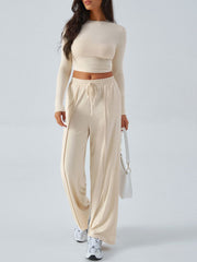Ribbed knit crop top and wide leg pants set in tan with drawstring waist and front seam detail.