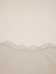 Beige ribbed long-sleeve top with delicate lace trim neckline.