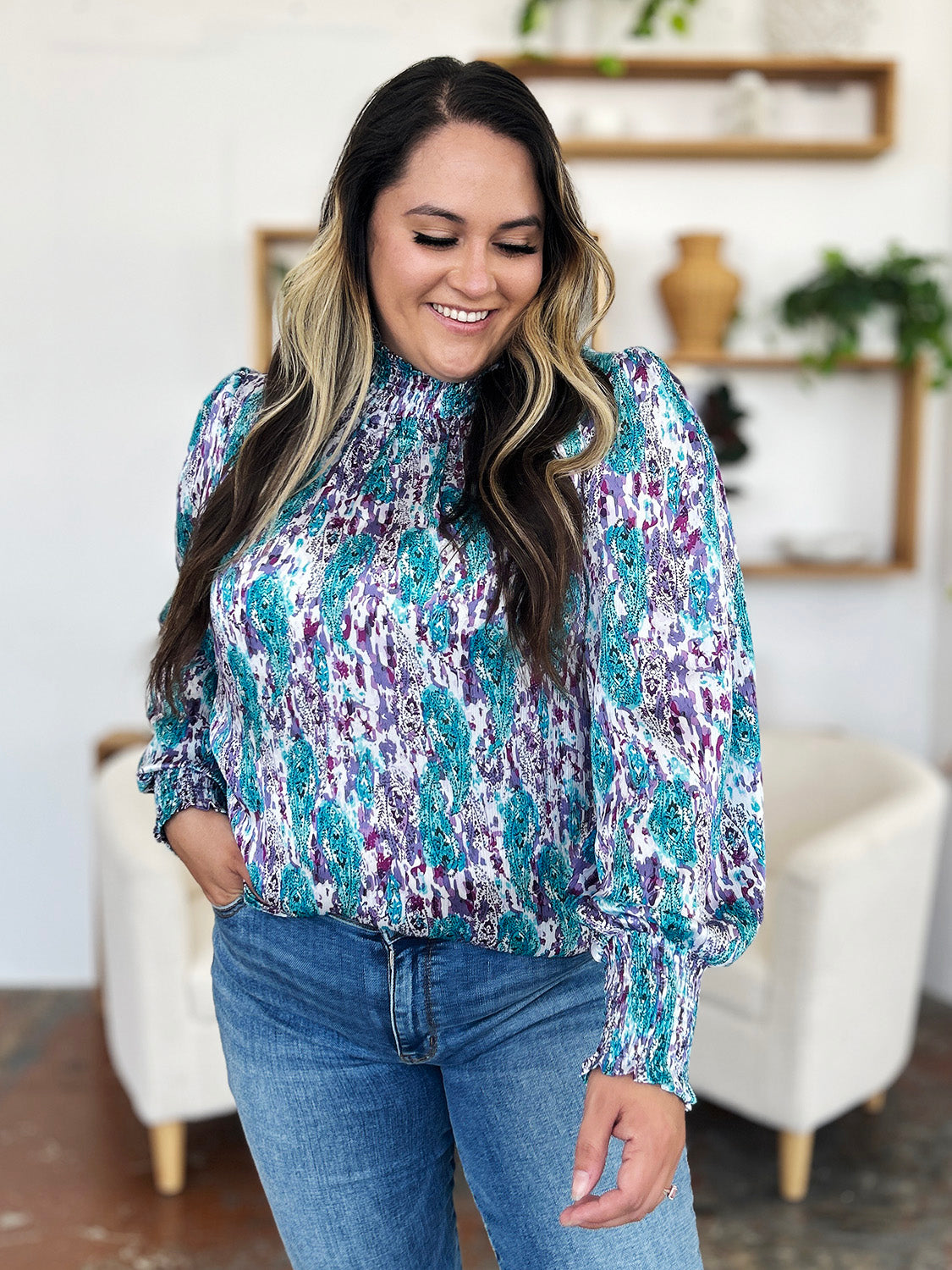 High neck abstract print blouse in blue and red-violet with smocked cuffs and neckline.