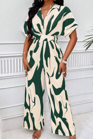 Dark green and cream abstract brushstroke wide-leg jumpsuit with short sleeves and a V-neck.