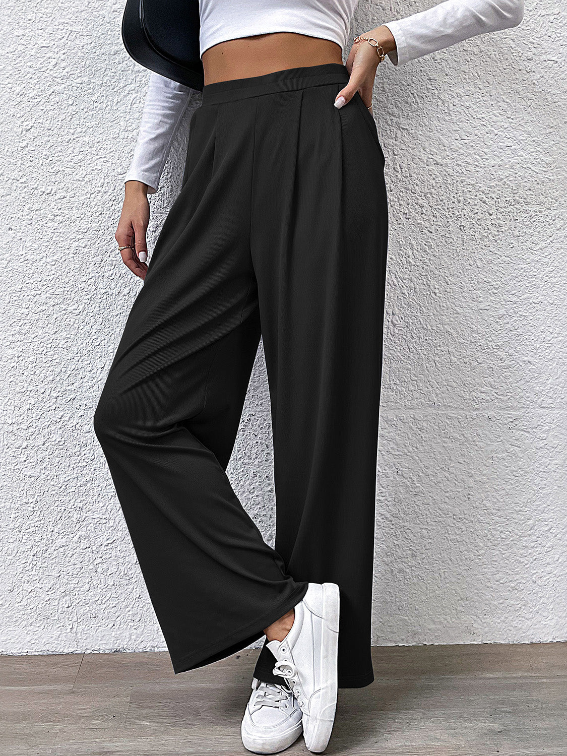 Black wide leg trousers with front pleats and a relaxed fit.