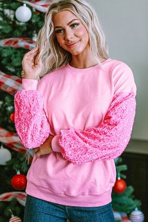 Pink sweatshirt with textured sequin sleeves and crew neck.