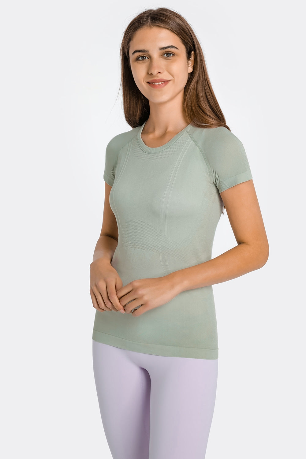 Sage green seamless activewear tee with crew neck and short sleeves, featuring subtle textured details.