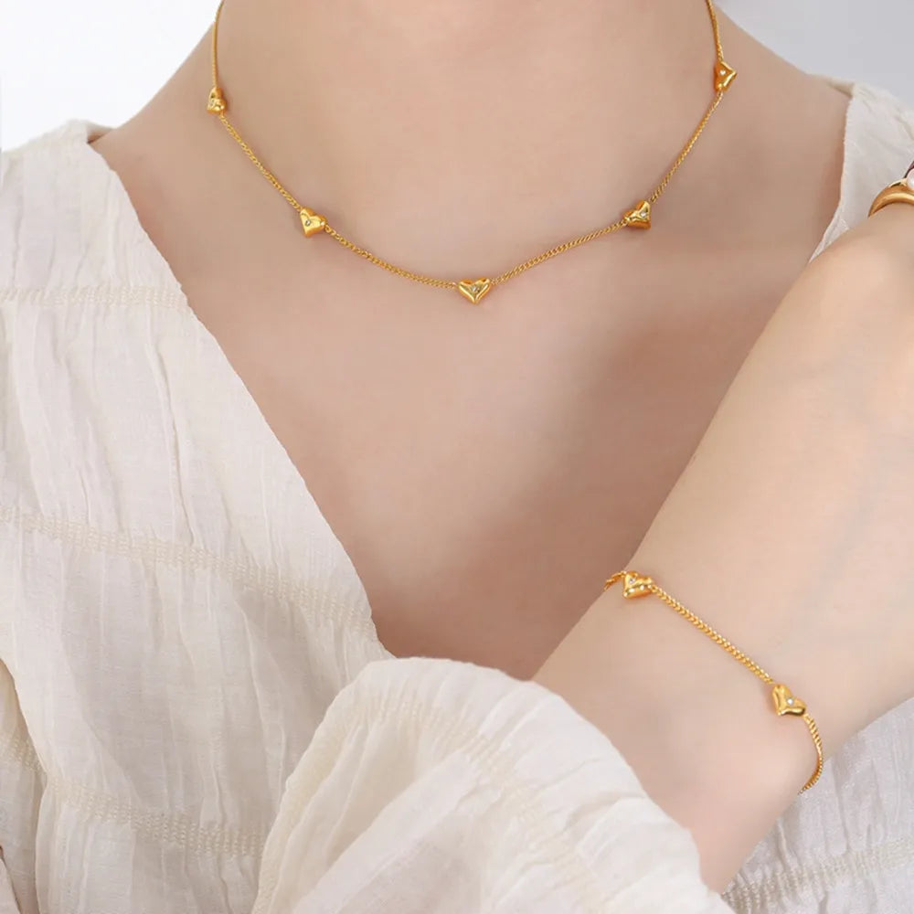 Gold chain necklace with scattered heart charms, 18K gold-plated.