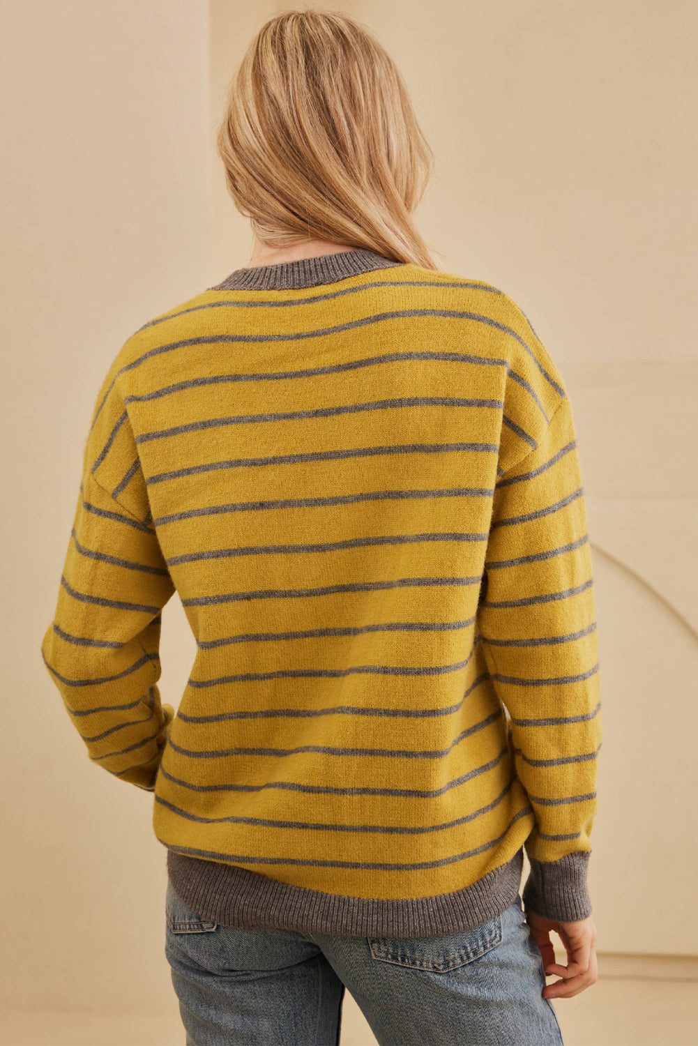 Yellow intarsia knit sweater with grey stripes and crew neck.
