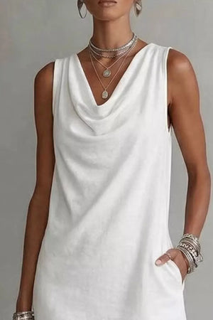 White cowl neck mini dress with pockets and layered necklaces.