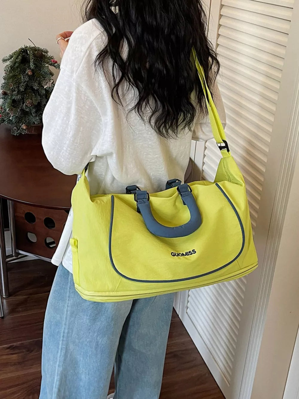 Chartreuse Oxford cloth duffle bag with blue trim and handles, showing brand logo.