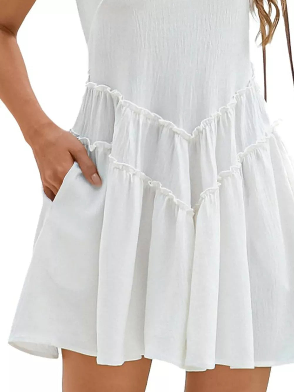 White frill tiered mini dress with pockets and ruffled details.