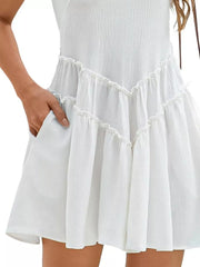 White frill tiered mini dress with pockets and ruffled details.