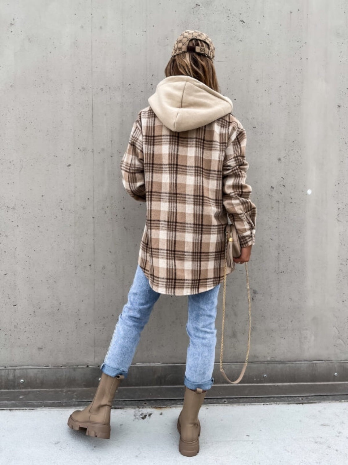 Oversized plaid shacket with attached hood in beige and brown, worn with jeans.