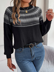 Black acrylic knit sweater with geometric yoke pattern and mock neck.