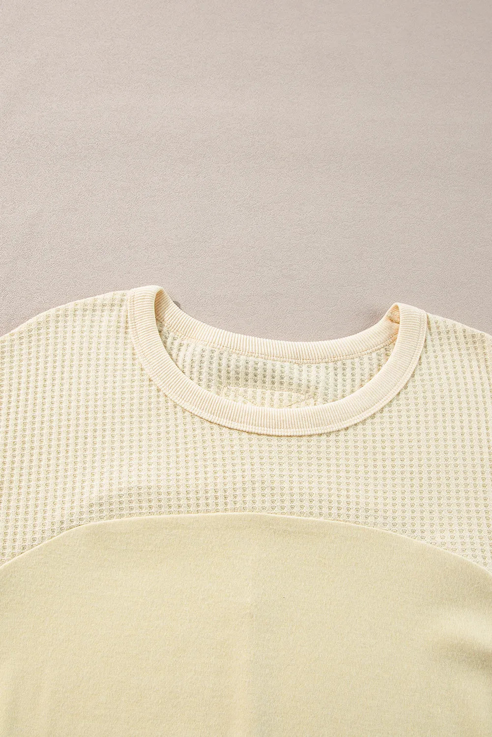 Beige waffle knit sweatshirt with colorblock detail and crew neck.