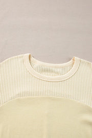 Beige waffle knit sweatshirt with colorblock detail and crew neck.